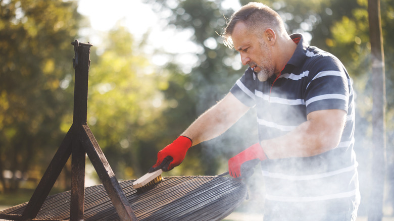 Man cleaning his grill