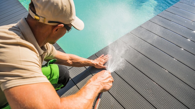 person washing pool deck