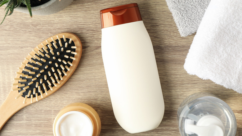 Bottle of conditioner with hairbrush