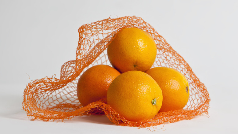 Oranges sitting in a produce net bag