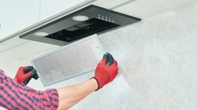 person removing range hood grate