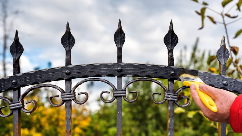 hand painting wrought iron fence with brush