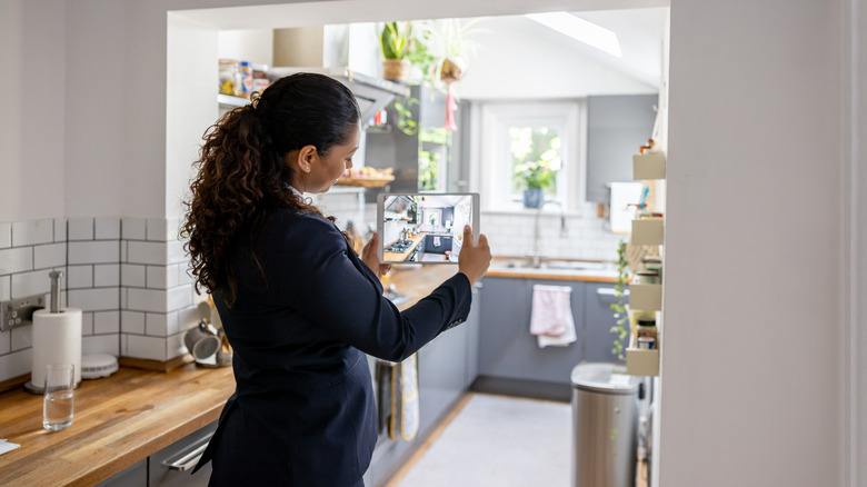 Woman taking photo of kitchen