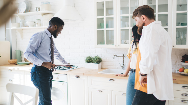 couple and real estate agent visiting house