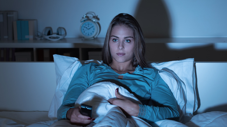 Woman watching TV late into the night