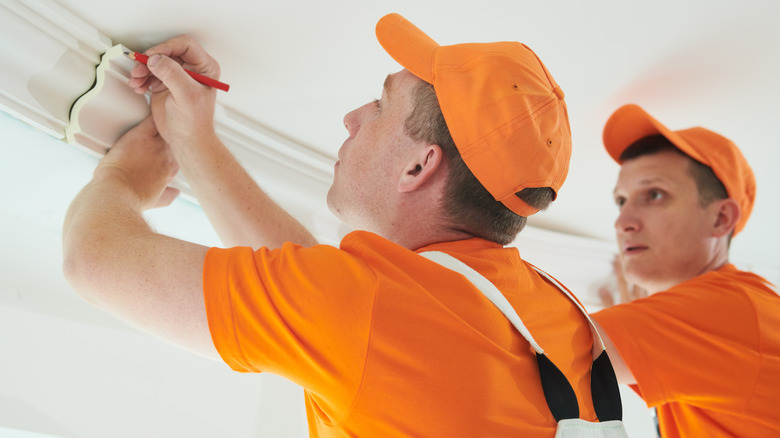 Workers installing PVC crown molding