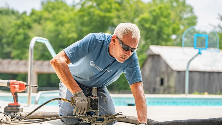 Man inspecting pool concrete