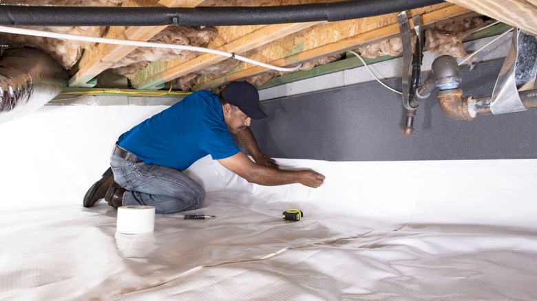 man inspecting crawl space