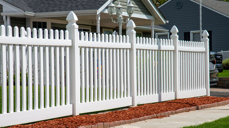 white pvc fence with lamp and house behind