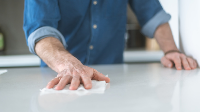 person using disinfecting wipe on counter