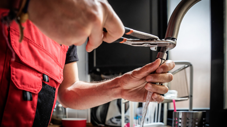 A person fixing a faucet