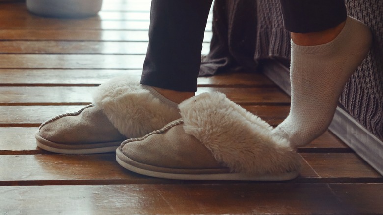 person putting slippers on