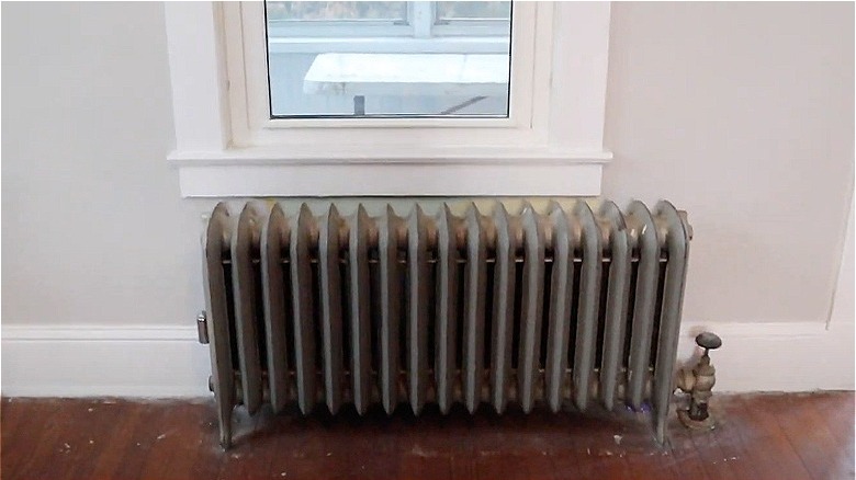 Metal radiator underneath window