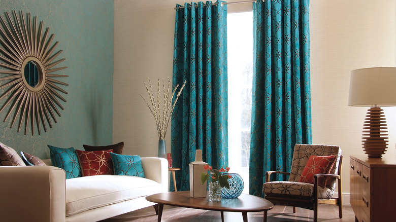 A contemporary living room with blue patterned curtains and wall