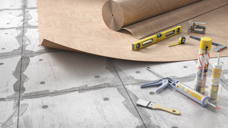 faux wood linoleum floor and tools over prepped subfloor