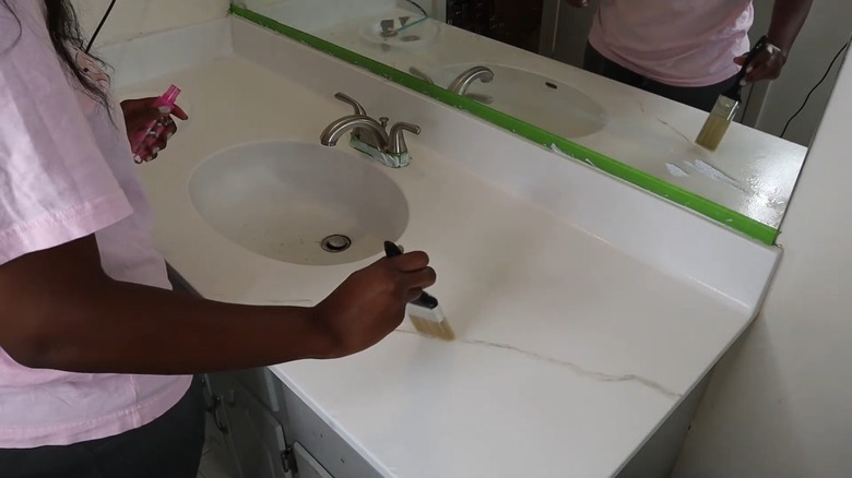 woman painting marble-effect on countertop