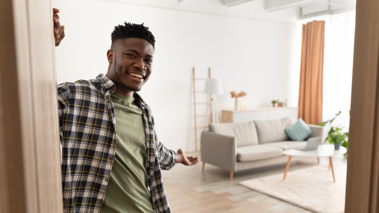 man opening door to home