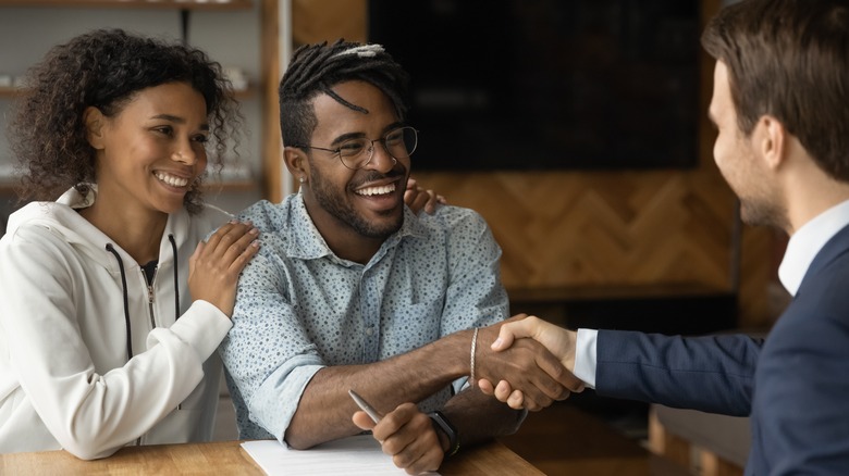 couple shaking hands with realtor