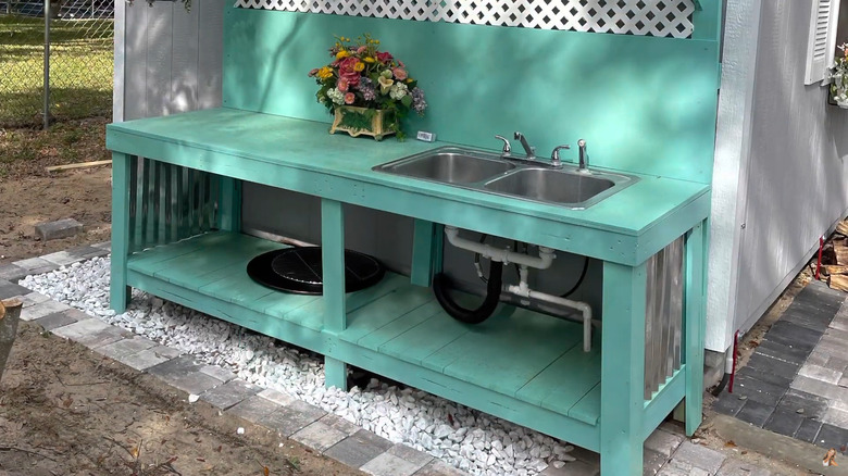 A kitchen sink situated outdoors with full plumbing hookups