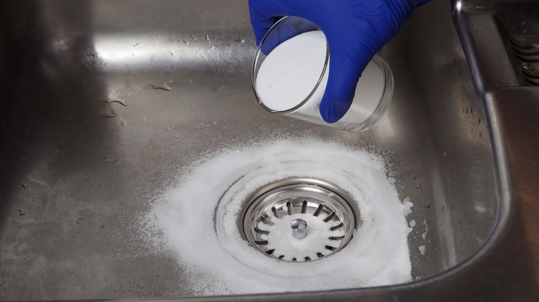 Pouring baking soda in the sinkhole