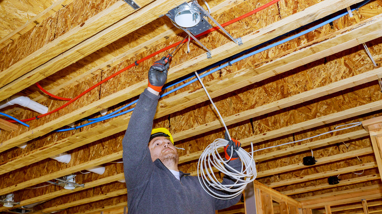Construction worker installing recessed light