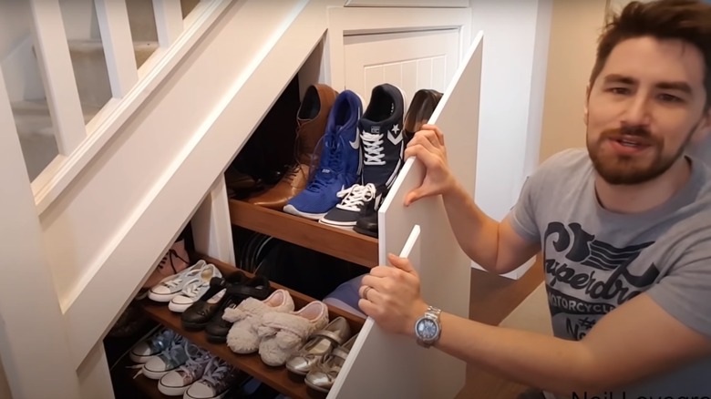 Man holding pull-out shoe storage