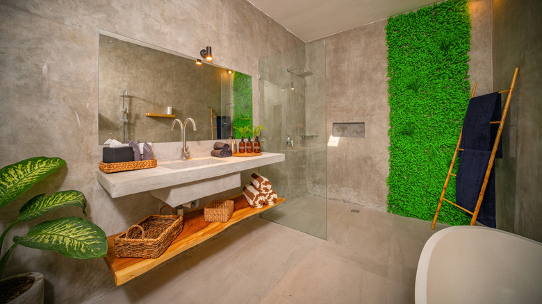 A bathroom is decorated with faux grass and a wood vanity