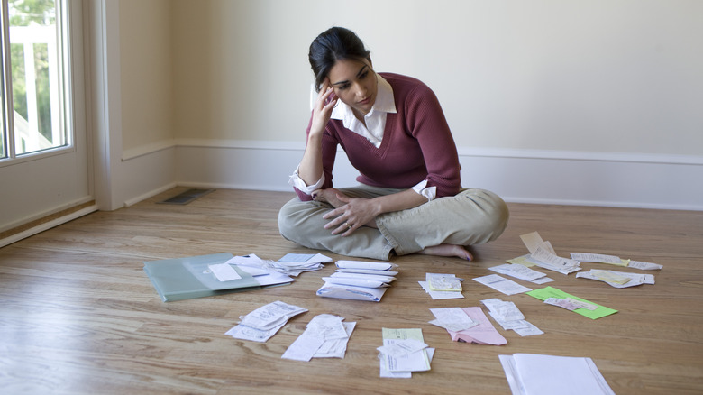 woman surrounded by bills 