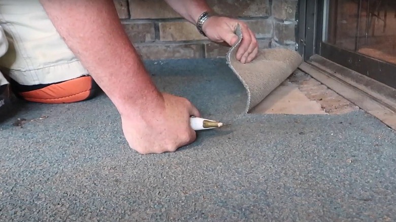 cutting old carpet for removal