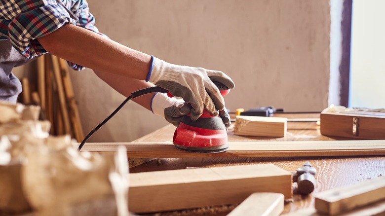 person using electric sander