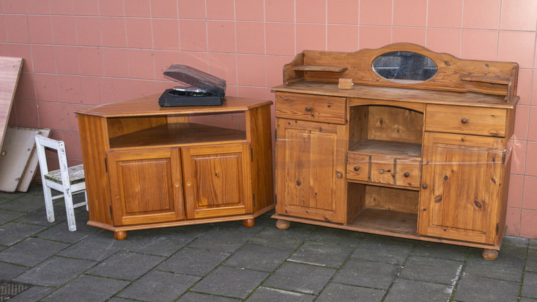 A pair of abandoned wood furniture pieces with wood drawers