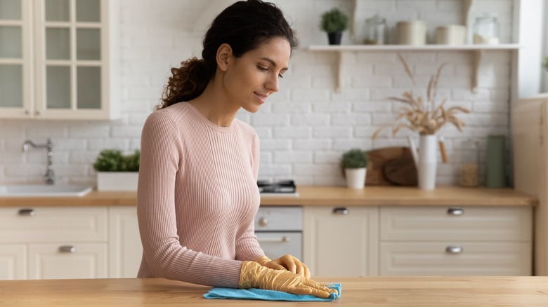 Woman wipes wood counter