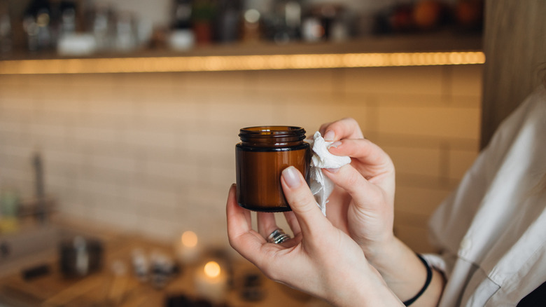 woman wiping a candle jar