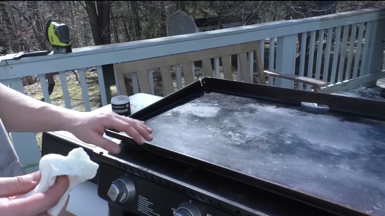 person cleaning Blackstone griddle