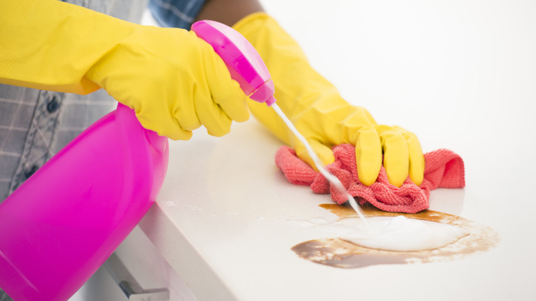 Spraying cleaner on countertop stain