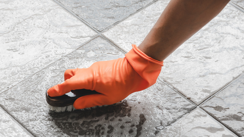 Person scrubbing pavers