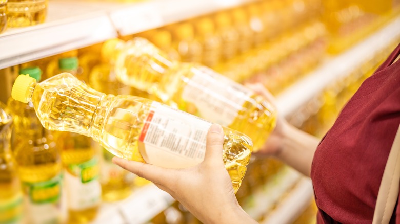 Woman holding vegetable oil bottles