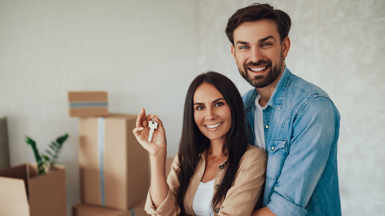 happy couple hold house keys