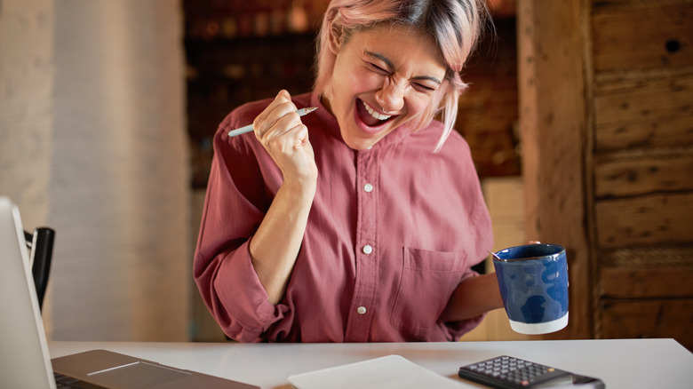 excited woman sitting at desk