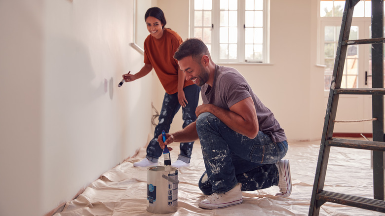 couple painting interior wall 