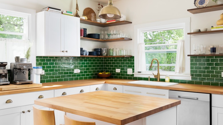 White kitchen with butcher block counters and green backsplash