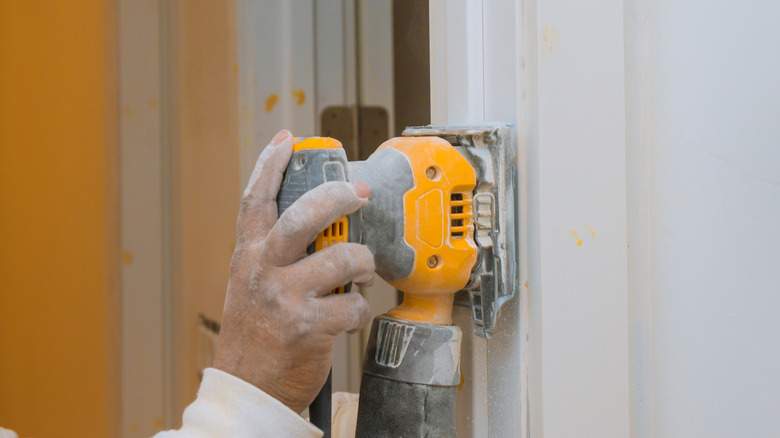 Person sanding door trim