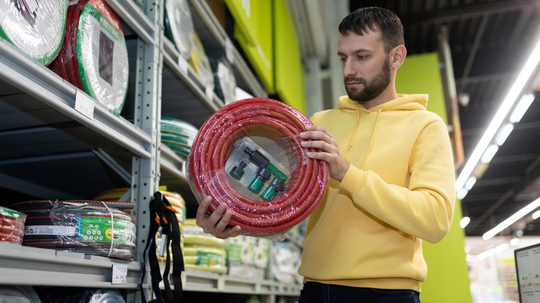 man buying a garden hose
