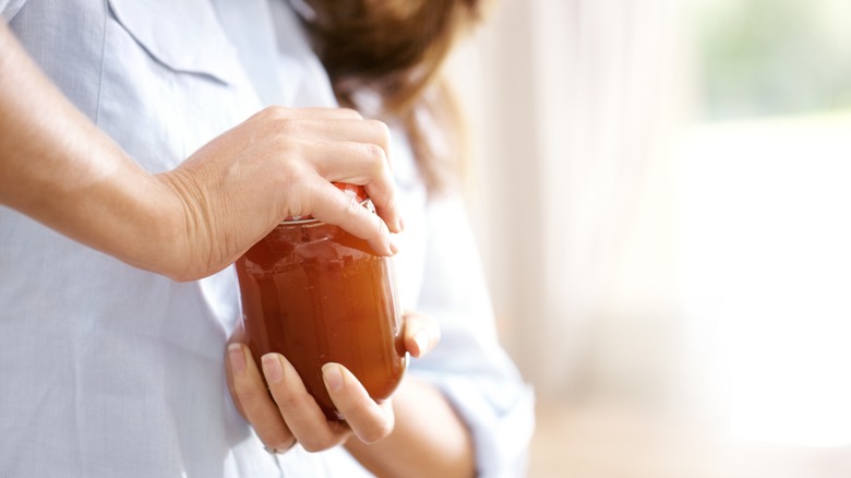 woman opening jar lid
