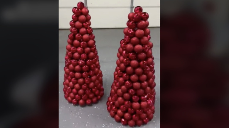 Two ornament trees made out of tomato cages with bright red baubles