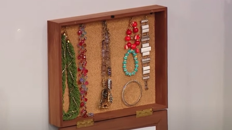 Shadow box with jewelry inside hanging on wall