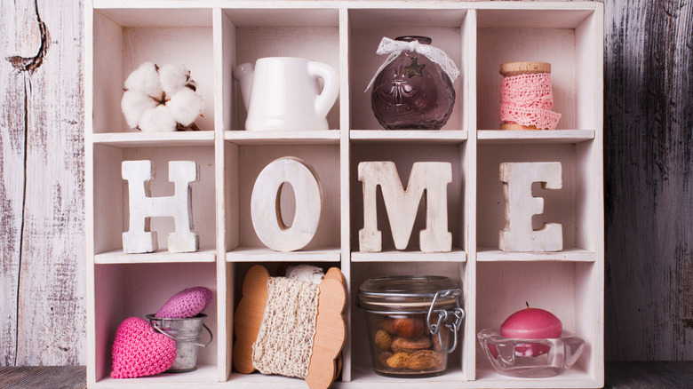 A shadow box filled with decorative items and letters spelling out HOME