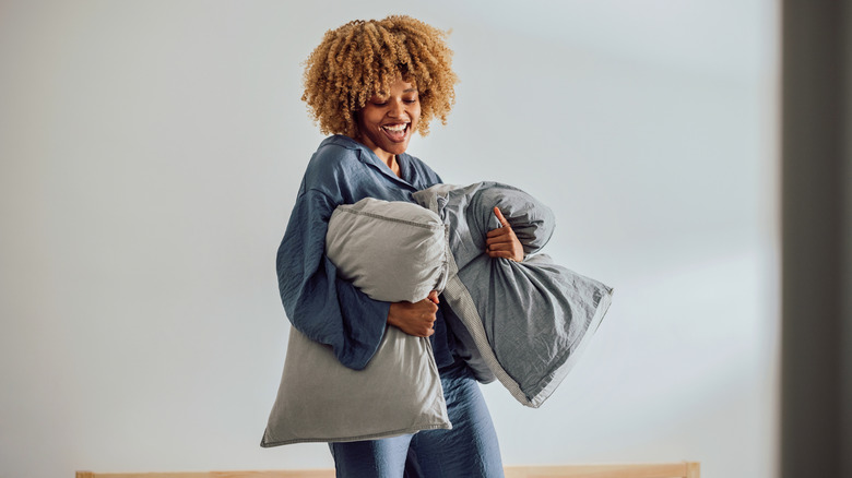 Someone holding onto two pillows