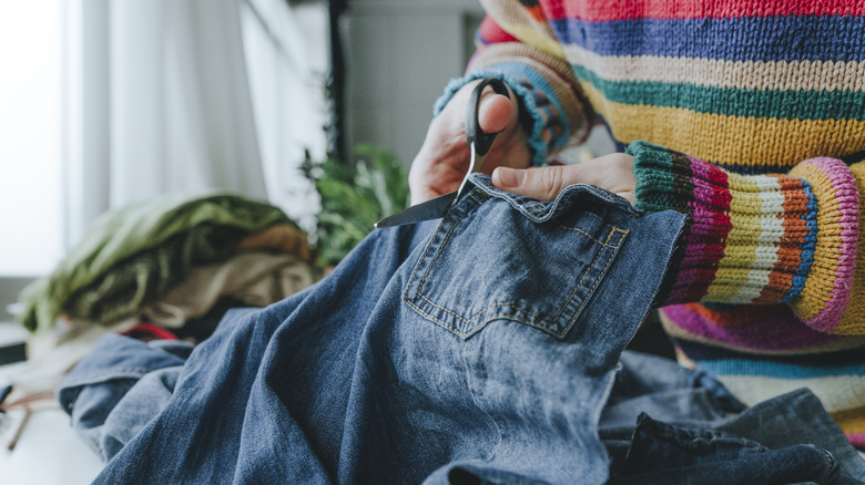 person cutting jeans