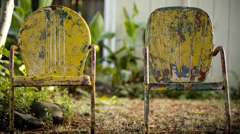 two rusting metal garden chairs